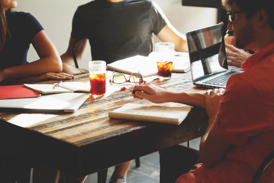 A business team collaborating around laptops on an AI rollout
